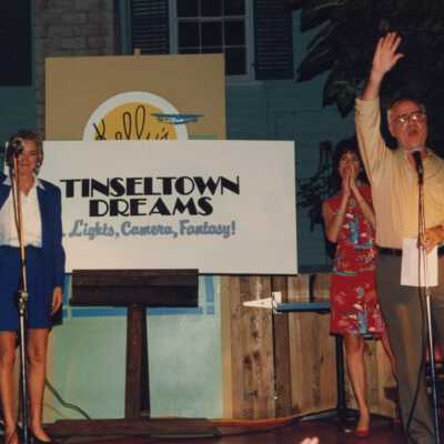 Rita Troxel and an unknown man and woman holding a sign that reads Tinseltown Dream.