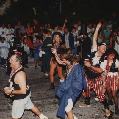 Unknown people dressed up walking in the street for the parade.
