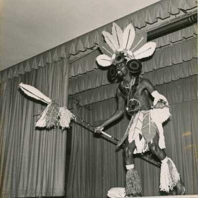 An unknown man in costume dancing on a stage