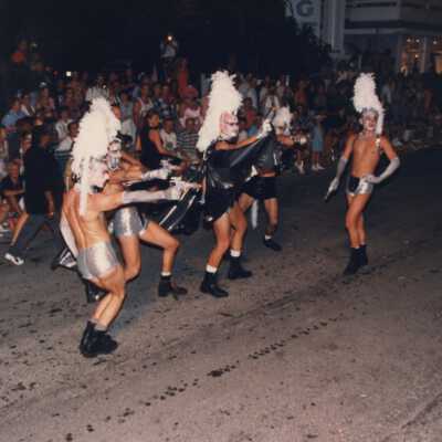 Unknown people dressed up walking in the street for the parade.