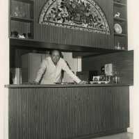 An unknown man standing in a kitchen