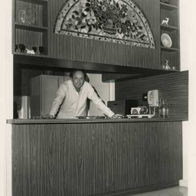 An unknown man standing in a kitchen