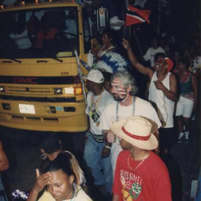 Unknown people walking next to a float in the parade.