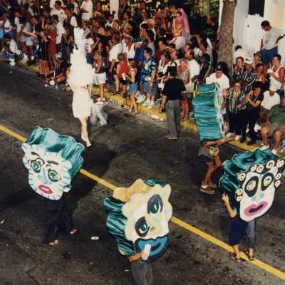 Unknown people dressed up walking in the street for the parade.