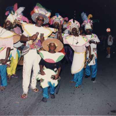 Unknown people dressed up dancing on the street for the parade.
