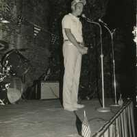 An unknown man standing at a microphone