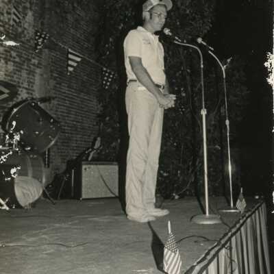 An unknown man standing at a microphone
