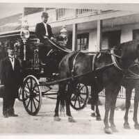          Horse-drawn hearse and two men
   