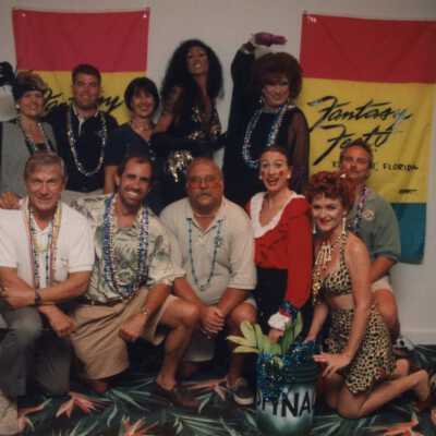 Unknown group of people standing in front of fantasy Fest flags.