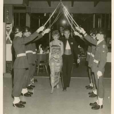 a couple walking under a U.S. Navy sword arch