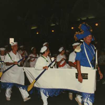 Unknown people dressed up walking in the street for the parade.