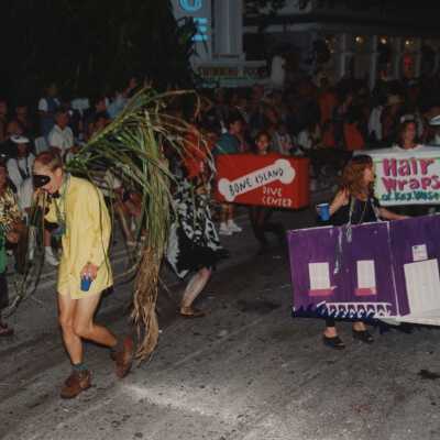 Unknown people dressed up walking in the street for the parade.