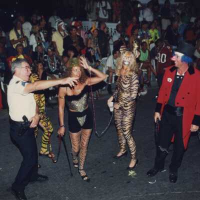 Unknown people dressed up walking in the street for the parade.
