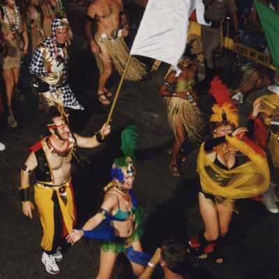 Unknown people dressed up walking in the street for the parade.