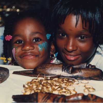 Two unknown kids near a booth at the Goombay celebration.