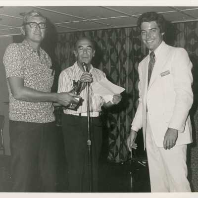 Unknown men standing at a microphone