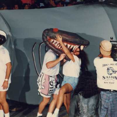 Unknown people walking with a float, while someone is recording them.