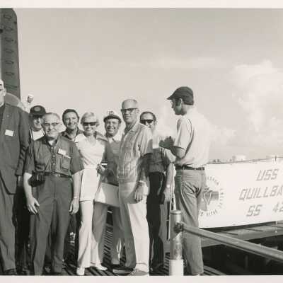 A group of unknown people standing next to the USS Quillback