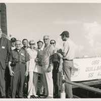 A group of unknown people standing next to the USS Quillback