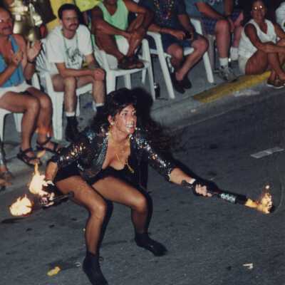 Unknown woman dressed up juggling fire.