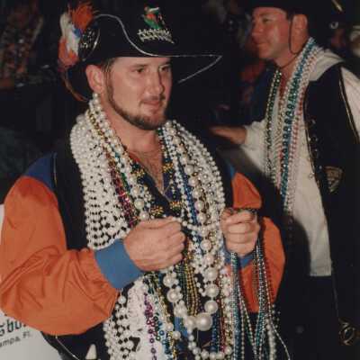 Unknown man dressed up with lots of beads around his neck.