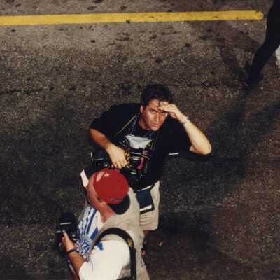 Two unknown photographers standing in the street.