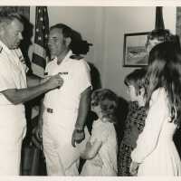 2 Men in uniform at a party with a family standing near by