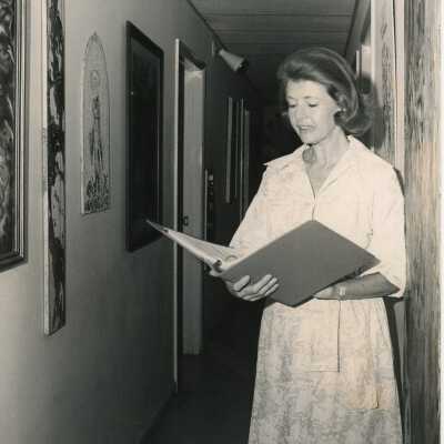 Unknown woman standing in a hallway reading information from a binder