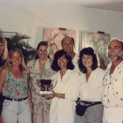 A group of unknown people accepting a trophy.