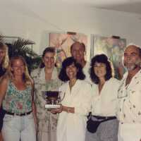 A group of unknown people accepting a trophy.