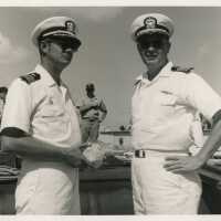 2 Unknown men in uniform, one is holding a shell