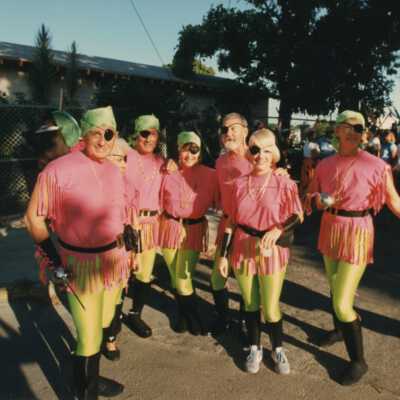 Unknown people dressed up standing outside.