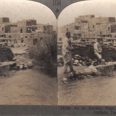 Stereoview of Native Americans in front of adobe buildings