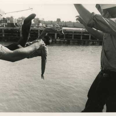 U.S. Navy men throwing one into the ocean