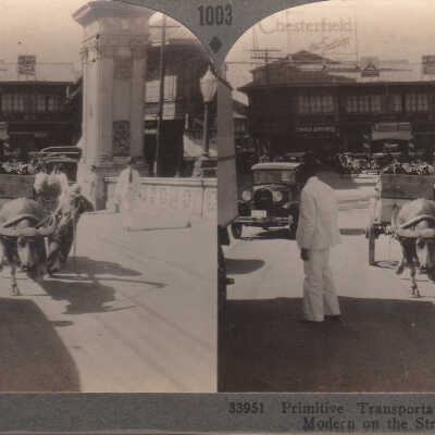 Stereoview of both cars and an ox cart in Manila, Philippine Islands