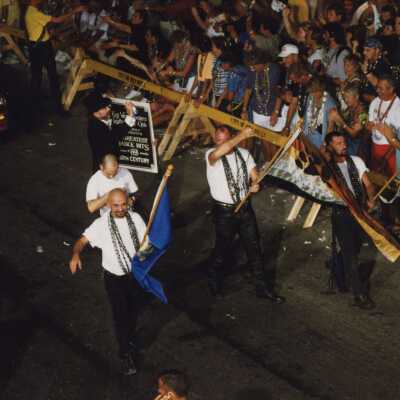Unknown people dressed up walking in the street for the parade.