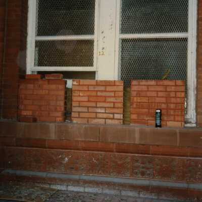 Windows labeled number 12 with bricks sitting in front of them.