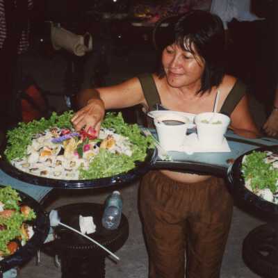 An unknown woman serving herself food.