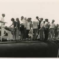 A group of unknown people standing on a ship
