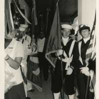 A group in uniform holding flags