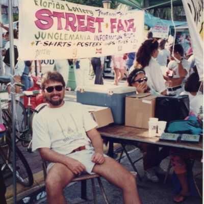 Unknown man sitting outside at the street fair.