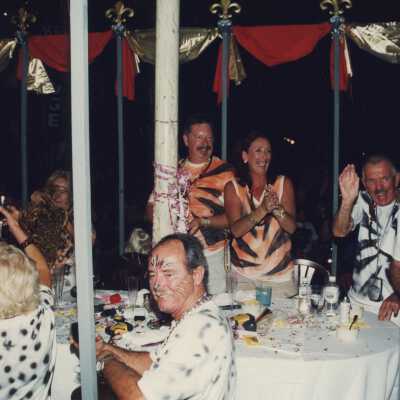 Unknown people dressed up sitting at tables.