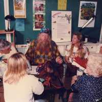 A group of unknown people sitting at a table talking.