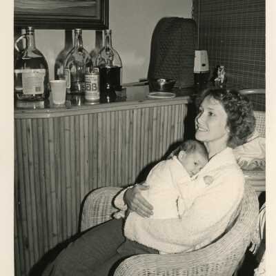 An unknown woman at a party holding a baby