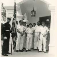 A group of unknown men in uniform standing outside of a building
