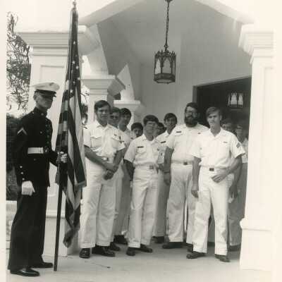 A group of unknown men in uniform standing outside of a building