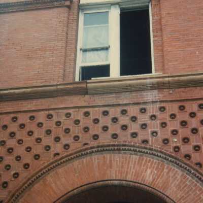 A brick arch and a second floor window.