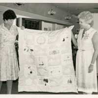 2 Unknown woman holding a quilt