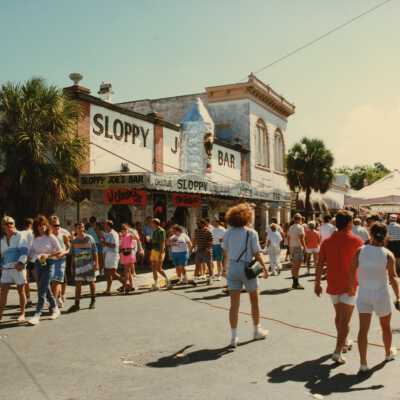 Unknown people walking in the street during the FF street fair in front of Sloppy Joe's bar.