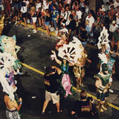 Unknown people dressed up walking down the street in the parade.